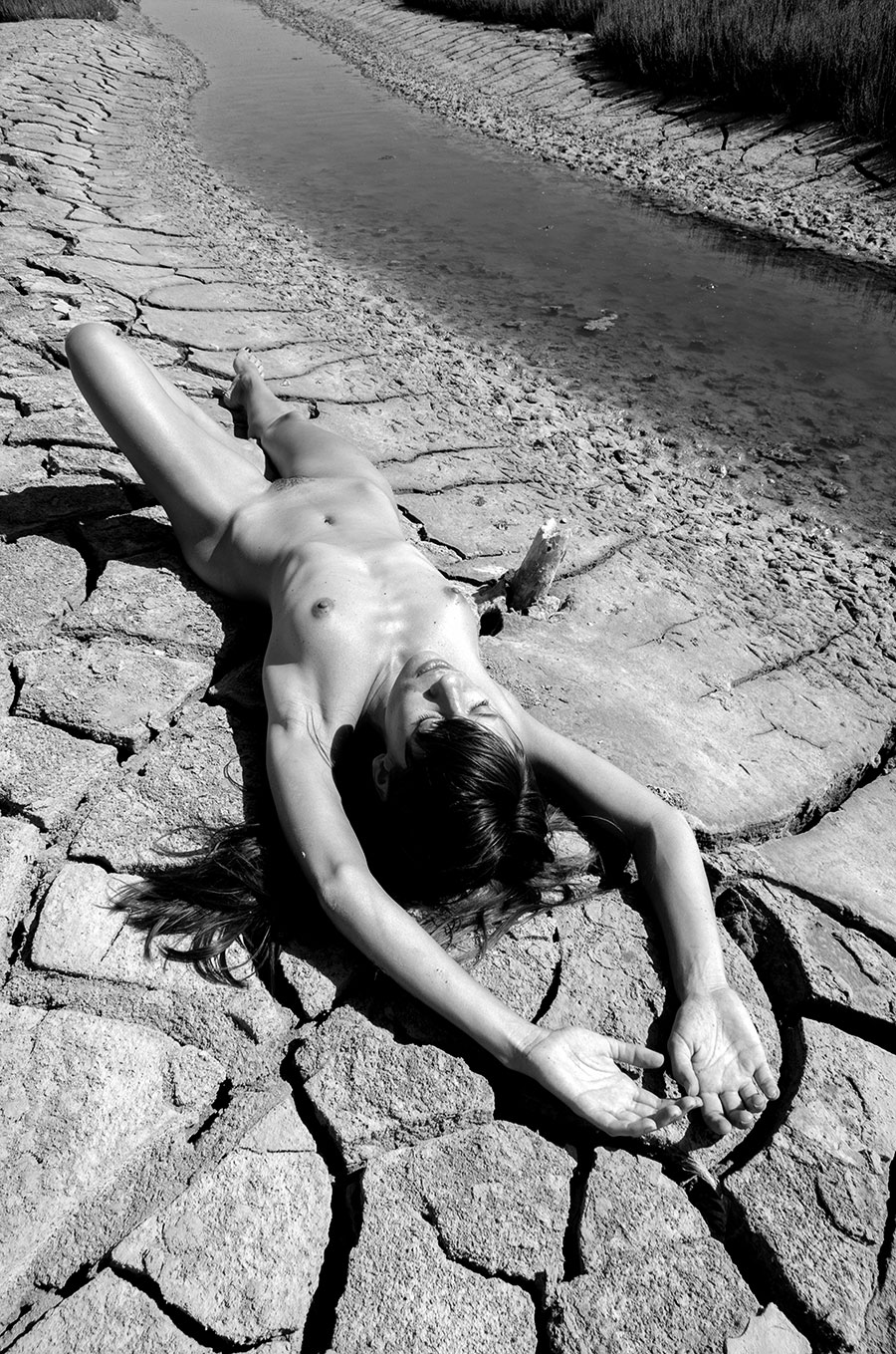 nu artistique en noir et blanc près d'une rivière